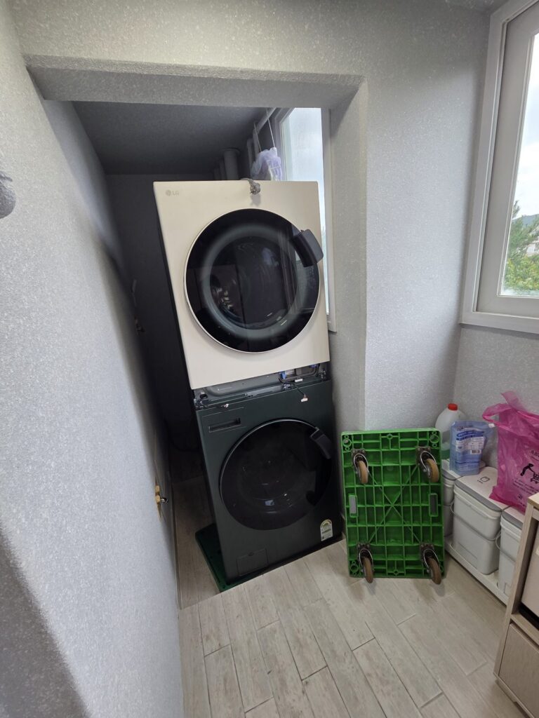 베란다 단 위에 설치된 타워형 세탁기 건조기
